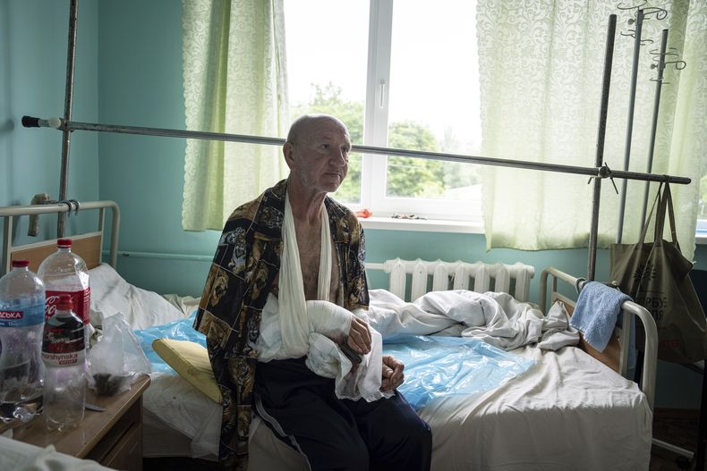 Vitalii Shpalin, de 60 años, en la cama de un hospital, el lunes 12 de junio de 2023, en la región de Jersón, Ucrania, después de ser baleado el domingo mientras intentaba escapar en bote de un poblado inundado en la cuenca del río Dniéper, en Ucrania. (AP Foto/Evgeniy Maloletka)