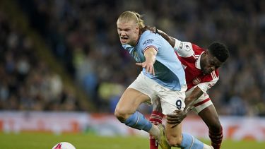 Thomas Partey (derecha) de Arsenal trata de retener a Erling Haaland del Manchester City en la Liga Premier, el miércoles 26 de abril de 2023, en Manchester. (AP Foto/Dave Thompson)