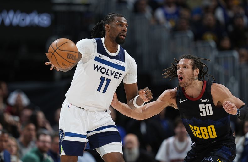 Naz Reid, izquierda, de los Timberwolves de Minnesota, pasa el balón mientra que Aaron Gordon, derecha, defiende en la primera mitad del Juego 2 de la serie de segunda ronda de playoffs del baloncesto de la NBA, el lunes 6 de mayo de 2024, en Denver. (AP Foto/David Zalubowski)