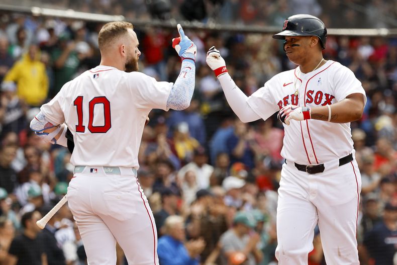 Rafael Devers, derecha, de los Medias Rojas de Boston, celebra con Trevor Story (10) después de batear un cuadrangular solitario en la quinta entrada del juego de béisbol de Grandes Ligas frente a los Yankees de Nueva York, el domingo 15 de junio de 2025, en Boston. (AP Foto/Greg M. Cooper)