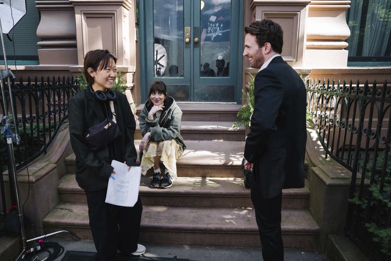 Esta imagen publicada por A24 muestra a Celine Song, de izquierda a derecha, Dakota Johnson y Chris Evans en el set de Materialists. (A24 via AP)