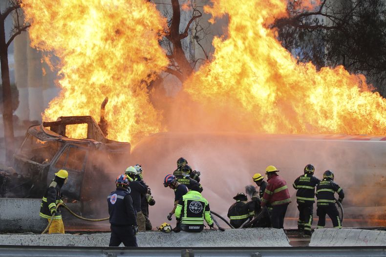 Bomberos rocían agua a un camión cisterna de gas que explotó bajo un paso elevado en Ciudad de México, el miércoles 10 de septiembre de 2025. (AP Foto/Tristan Velazquez)