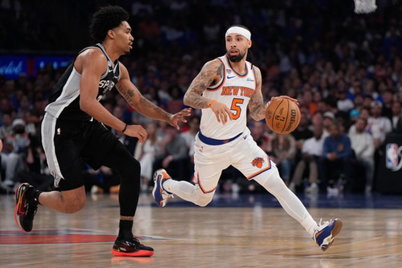 El base de los Knicks de Nueva York, José Alvarado (5), avanza con el balón mientras el base de los Spurs de San Antonio, Dylan Harper, defiende durante la primera mitad del cuarto partido de la serie de las Finales de la NBA, el miércoles 10 de junio de 2026, en Nueva York. (Foto AP/Ross D. Franklin)