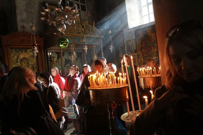 Fieles cristianos miran velas encendidas en la Iglesia de la Natividad, en la ciudad cisjordana de Bel&eacute;n, el lunes 23 de diciembre de 2013. (Foto AP/Nasser Shiyoukhi)