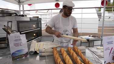 El panadero francés Tony Dore prepara baguettes como las que les ofrecerán a los deportistas durante los Juegos Olímpicos de París el martes 30 de abril del 2024. (AP Foto/Michel Euler)