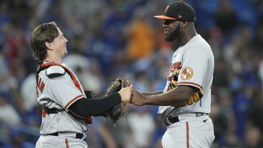 El receptor Adley Rutschman (izquierda) y el relevista Félix Bautista celebran tras la victoria ante los Azulejos de Toronto, el lunes 31 de julio de 2023, en Toronto. (Nathan Denette/The Canadian Press vía AP)