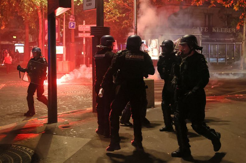 Policías intentan dispersar a aficionados del PSG, que encendieron bengalas para celebrar en París, el sábado 30 de mayo de 2026 después de la final de la Liga de Campeones entre el Paris Saint-Germain y el Arsenal, disputada en Budapest. El PSG ganó el encuentro. (AP Foto/Thomas Padilla)