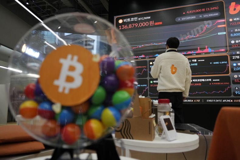 Un empleado observa un cartel electrónico que muestra los precios de bitcoin y otras criptomonedas en la sala de intercambio de criptomonedas Bithumb en Seúl, Corea del Sur, 21 de noviembre de 2024. (AP foto/Ahn Young-joon, archivo)