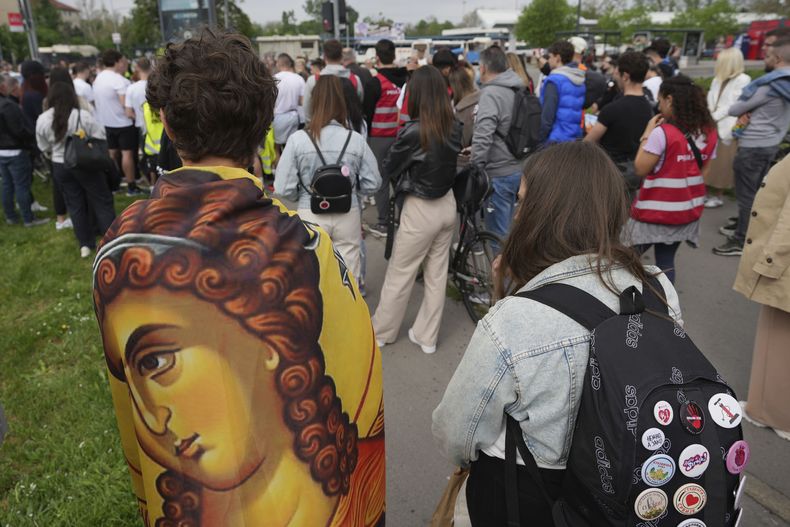 Un grupo de personas permanece en silencio para conmemorar el fatídico derrumbe del dosel de una estación de trenes en una ceremonia de despedida realizada por estudiantes serbios en Novi Sad, Serbia, el viernes 25 de abril de 2025. (AP Foto/Darko Vojinovic)