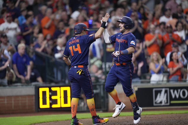 Alex Bregman de los Astros de Houston celebra con Mauricio Dubon después de que ambos anotaron con el jonrón de Bregman en el encuentro ante los Cachorros de Chicago el lunes 15 de mayo del 2023. (AP Foto/David J. Phillip)