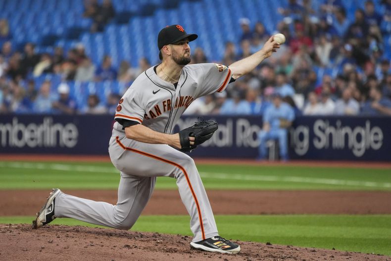 El abridor de los Gigantes de San Francisco Alex Wood lanza en la segunda entrada del juego ante los Azulejos de Toronto el martes 27 de junio del 2023. (Andrew Lahodynskyj/The Canadian Press via AP)