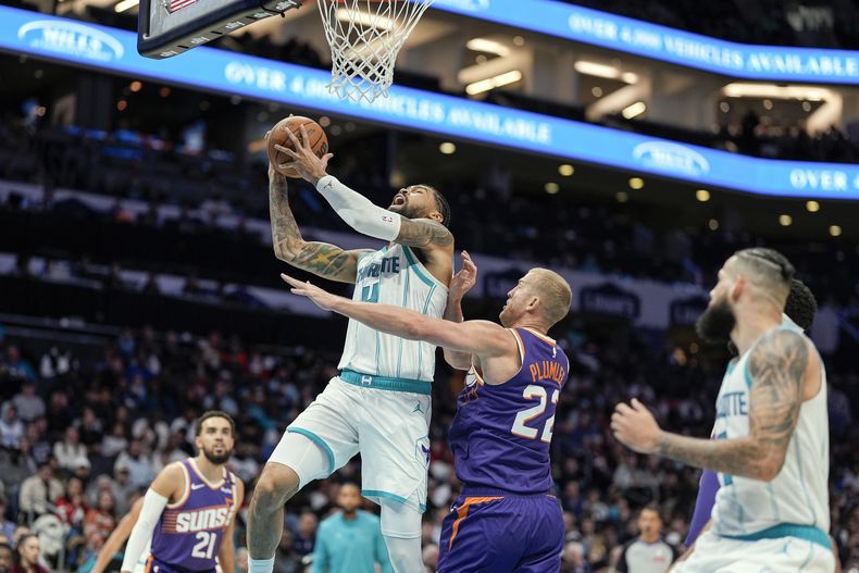 Nick Richards, de los Hornets de Charlotte, recibe una falta de Mason Plumlee, de los Suns de Phoenix, el martes 7 de enero de 2025 (AP Foto/Jim Dedmon)