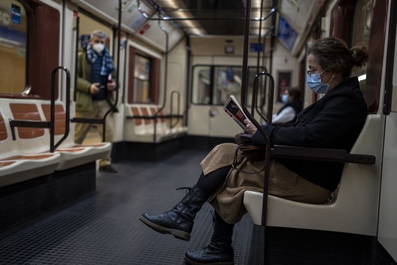 ARCHIVO - Una mujer con mascarilla viaja en el metro de Madrid, 20 de enero de 2022. El gobierno declaró el martes 4 de julio de 2023 el fin de la crisis sanitaria provocada por el COVID-19. El uso de la mascarilla ha dejado de ser obligatorio en hospitales, asilos, farmacias y el transporte público. (AP Foto/Manu Fernández, File)