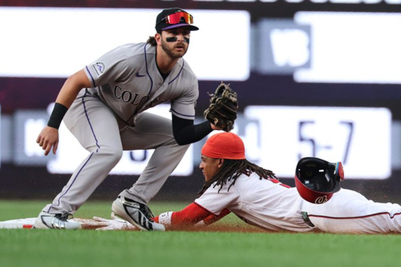CJ Abrams de los Nacionales de Washington se desliza para robarse la segunda base frente a Connor Norby de los Rockies de Colorado, el lunes 24 de agosto de 2026, en Washington. (AP Foto/Terrance Williams)