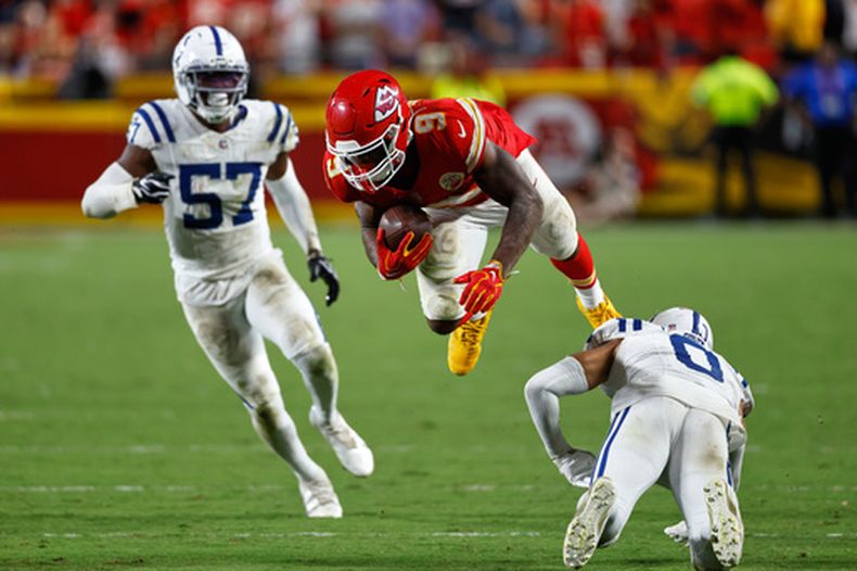 Kenneth Walker III (9), corredor de los Chiefs de Kansas City, es derribado por Cam Bynum (0), safety de los Colts de Indianápolis, mientras el linebacker Jaylon Carlies (57) observa durante el tiempo extra del partido de la NFL del domingo 20 de septiembre de 2026, en Kansas City, Missouri. (AP Foto/Colin E. Braley)