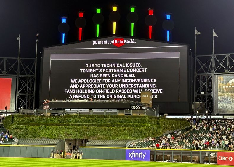 Un mensaje en el videomarcador del estadio Guaranteed Rate Field anuncia la cancelación del concierto que debían ofrecer Vanilla Ice, Tone Loc y Rob Base tras un partido de béisbol entre los Medias Blancas de Chicago y los Atléticos de Oakland, el 25 de agosto de 2023, en Chicago. (AP Foto/Charles Rex Arbogast)