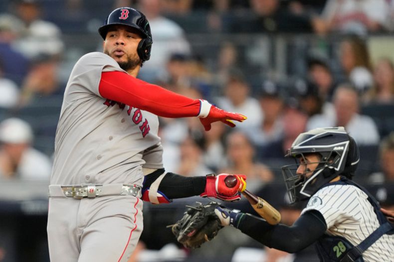Willson Contreras, de los Medias Rojas de Boston, golpea en el brazo con su bate al receptor de los Yankees de Nueva York, Austin Wells, durante la primera entrada de un partido de béisbol, el viernes 28 de agosto de 2026, en Nueva York. (Foto AP/Yuki Iwamura)