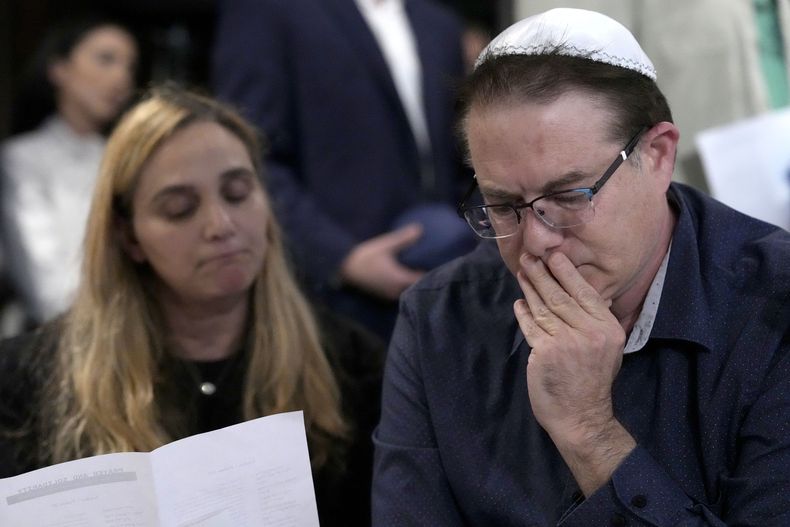 Avi Zamir (derecha), y su esposa Sigal escuchan durante una oración para Judith Raanan y su hija Natalie, el jueves 12 de octubre de 2023, en Evanston, Illinois. (AP Foto/Charles Rex Arbogast)