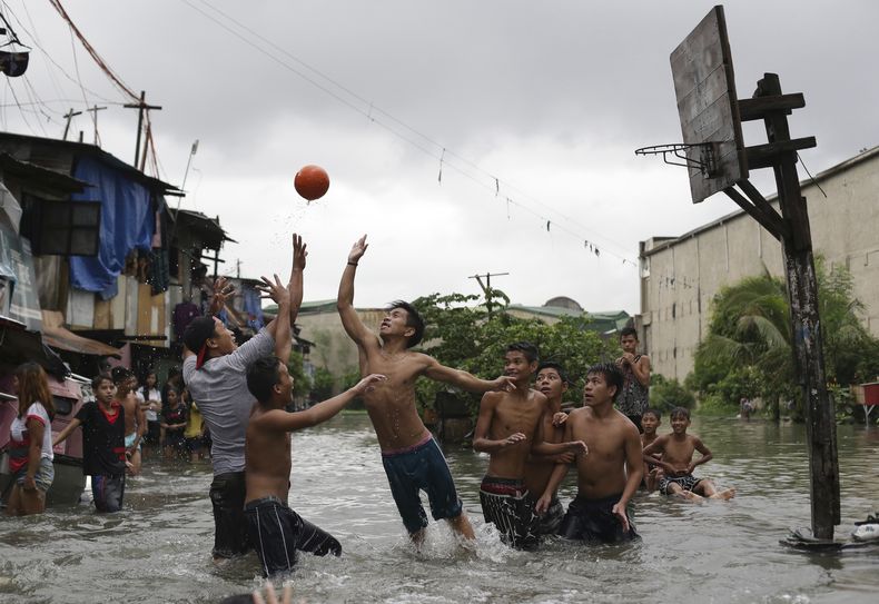 ARCHIVO - Jóvenes filipinos juegan basquetbol en la aldea de Malabon, al norte de Manila, el miércoles 8 de julio de 2015. (AP Foto/Aaron Favila)