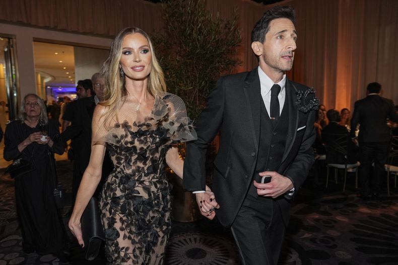 Georgina Chapman, izquierda, y Adrien Brody llegan a la 82ª edición de los Globos de Oro el domingo 5 de enero de 2025 en el Beverly Hilton de Beverly Hills, California. (Foto AP/Chris Pizzello)