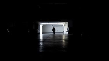 Un hombre camina por un garaje durante un apagón masivo, en Santiago, Chile, el martes 25 de febrero de 2025. (AP Foto/Matías Basualdo)