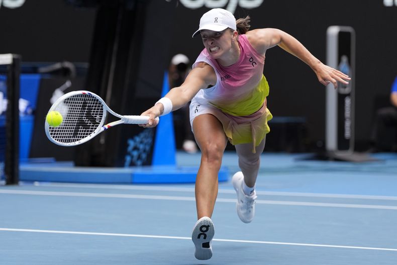 La polaca Iga Swiatek hace una devolución de revés hacia la estadounidense Emma Navarro, en los cuartos de final del Abierto de Australia, el miércoles 22 de enero de 2025 (AP Foto/Vincent Thian)