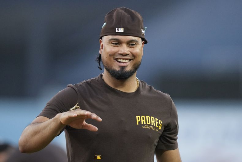 El venezolano Luis Arráez, de los Padres de San Diego, sostiene una mantis religiosa en el dorso de su mano antes del quinto juego de la serie divisional ante los Dodgers de Los Ángeles, el jueves 10 de octubre de 2024 (AP Foto/Ashley Landis)