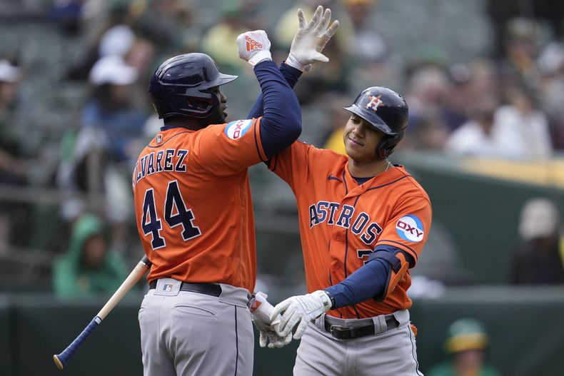 Jeremy Peña de los Astros de Houston felicita a Yordan Álvarez tras su jonrón de dos carreras en la novena entrada del juego ante los Atléticos de Oakland el domingo 28 de mayo del 2023. (AP Foto/Jeff Chiu)
