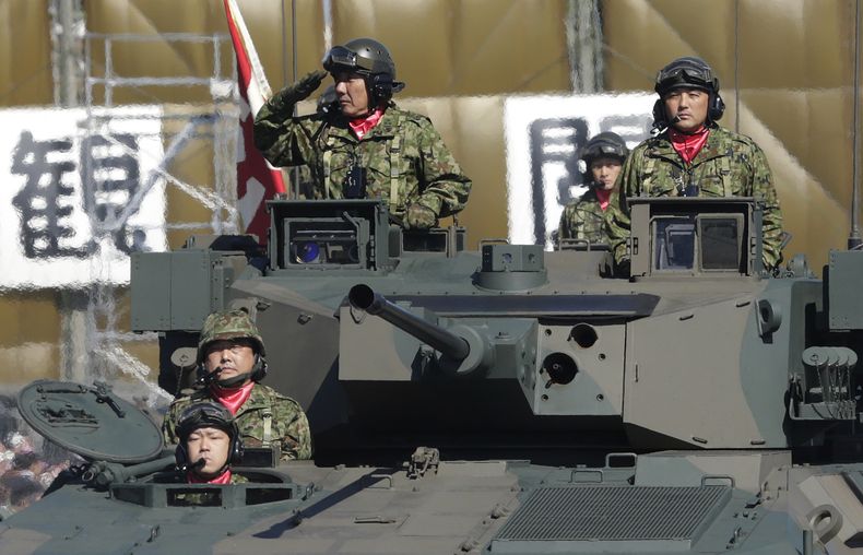 EN fotograf&iacute;a del 27 de octubre de 2013 un integrante de las Fuerzas terrestres de Autodefensa de Jap&oacute;n sa&ntilde;uda desde un veh&iacute;culo blindado de combate tipo-89 durante un desfile por al d&iacute;a de ese cuerpo en la base de Asaka