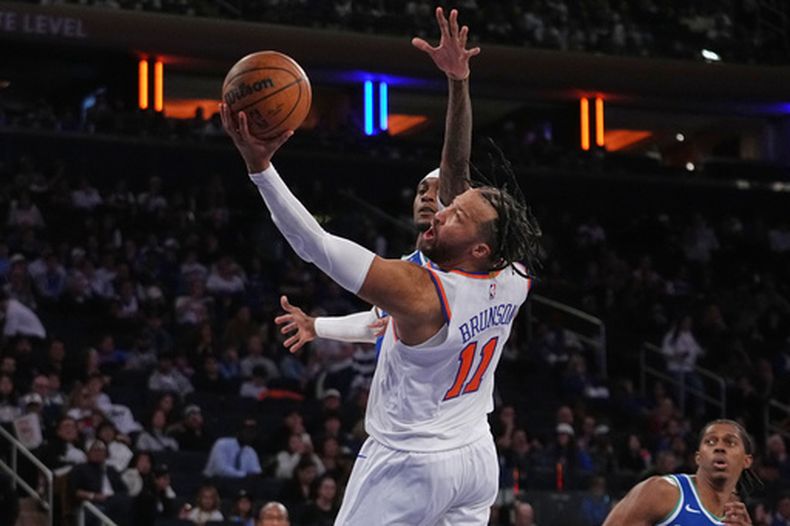 Jalen Brunson (11), de los Knicks de Nueva York, avanza con el balón ante Jaden McDaniels (3), de los Timberwolves de Minnesota, durante la segunda mitad de un partido de básquetbol de pretemporada de la NBA, el lunes 12 de octubre de 2026, en Nueva York. (Foto AP/Frank Franklin II)