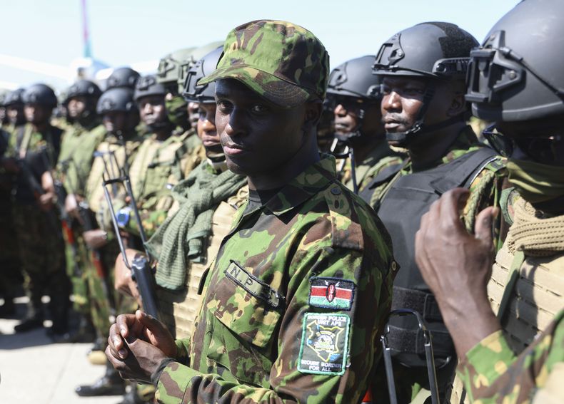 Policías kenianos --los cuales forman parte de una fuerza multinacional respaldada por la ONU-- permanecen sobre la pista tras aterrizar en el Aeropuerto Internacional Toussaint Louverture, el sábado 18 de enero de 2025, en Puerto Príncipe, Haití. (AP Foto/Odelyn Joseph)