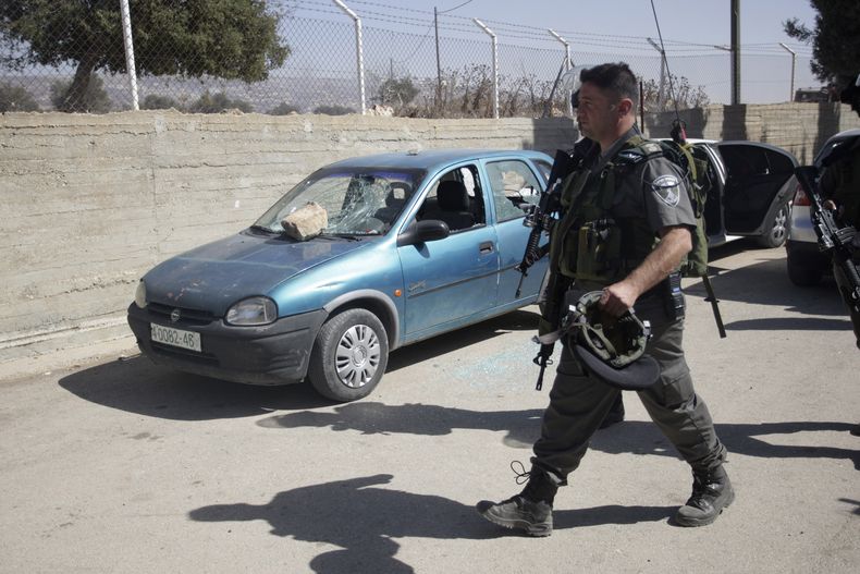 Un polic&iacute;a israel&iacute; camina junto a un autom&oacute;vil da&ntilde;ado en el patio de una escuela en la aldea de Jaloud, en Cisjordania, el mi&eacute;rcoles, 9 de octubre del 2013. Residentes dela aldea dijeron que colonos jud&iacute;os enmasca