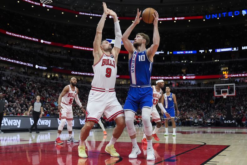 Domantas Sabonis, alero de los Kings de Sacramento, dispara frente a Nikola Vucevic, de los Bulls de Chicago, el sábado 3 de febrero de 2024 (AP Foto/Erin Hooley)