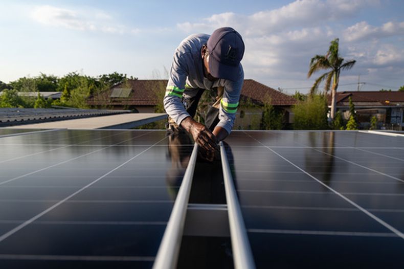 Un instalador solar fija un panel solar en la azotea de una casa en Manila, Filipinas, el 30 de abril de 2026. (AP Foto/Anton L. Delgado)
