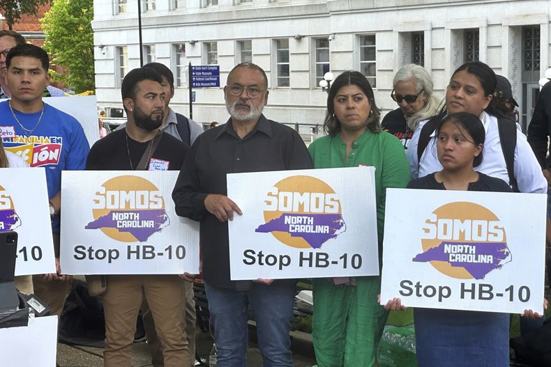 ARCHIVO - Opositores a una medida que se debate en la Asamblea General de Carolina del Norte que podría requerir que los jefes de policía cooperen con las solicitudes de los agentes federal interesados en recoger reclusos que se cree estén en el país ilegalmente protestan contra la medida el 1 de mayo de 2024, afuera del Capitolio, en Raleigh, Carolina del Norte. (AP Foto/Gary D. Robertson, Archivo)
