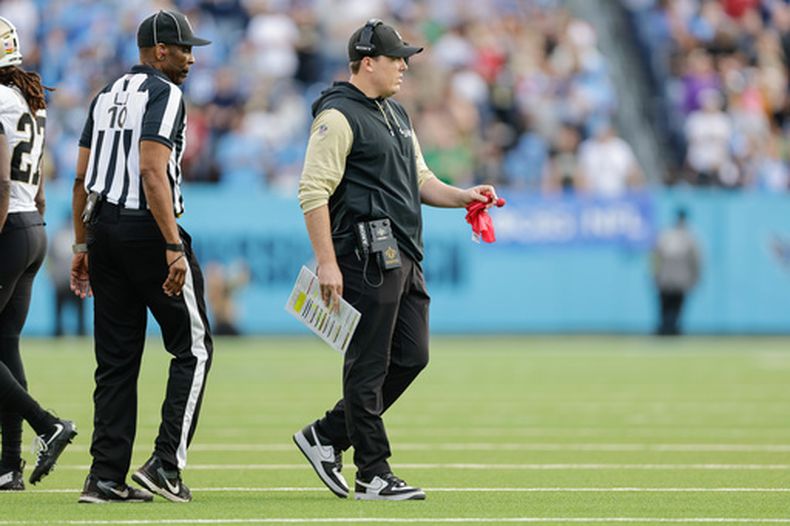 ARCHIVO - El entrenador en jefe de los Saints de Nueva Orleans, Kellen Moore, se prepara para lanzar la bandera roja de desafío durante la segunda mitad de un partido de fútbol americano de la NFL contra los Titans de Tennessee, el 28 de diciembre de 2025, en Nashville, Tennessee. (Foto AP/Stew Milne, Archivo)