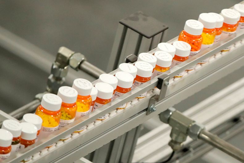 ARCHIVO - Envases de medicamentos se desplazan por una cinta transportadora en un almacén de una farmacia de venta por correo en Florence, Nueva Jersey, el 10 de julio de 2018. (AP Foto/Julio Cortez, Archivo)