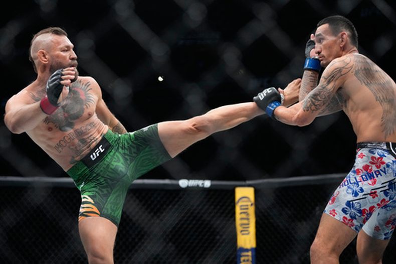Conor McGregor, izquierda, intenta conectar una patada a Max Holloway en su combate de peso welter en la función de artes marciales mixtas UFC 329, el sábado 11 de julio de 2026, en Las Vegas. (AP Foto/John Locher)