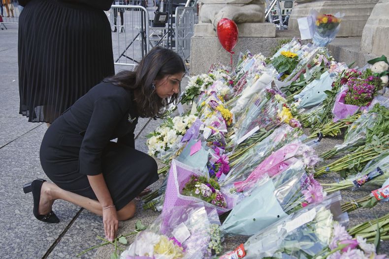 La secretaria del Interior británica, Suella Braverman, contempla las flores colocadas en la escalinata del ayuntamiento de Nottingham, Gran Bretaña, 15 de junio de 2023, en el lugar donde tres personas murieron y otras tres resultaron heridas en un ataque el martes. (Peter Byrne/PA via AP)