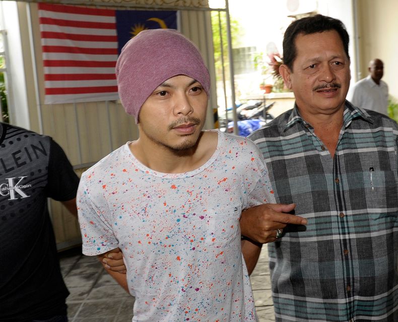 ARCHIVO - Wee Meng Chee, a la izquierda, un rapero malasio conocido popularmente como Namewee, es escoltado por policías de paisano a su llegada a la corte de magistrados en Penang, Malasia, el 22 de agosto de 2016. (AP Foto/Gary Chuah, Archivo)