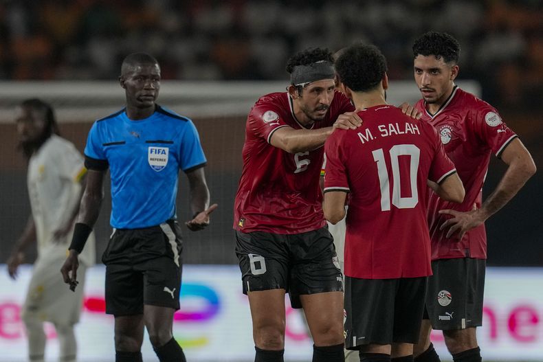 El delantero de Egipto Mohamed Salah (10) conversa con sus compañeros tras contraer una lesión durante el partido frente a Ghana por el grupo B de la Copa Africana de Naciones, en Abiyán, Costa de Marfil, el jueves 18 de enero de 2024. (AP Foto/Themba Hadebe)