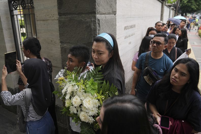 Varias personas hacen fila para entrar a la Nunciatura Apostólica para presentar sus condolencias por la muerte del papa Francisco, en Yakarta, Indonesia, el 22 de abril de 2025. (AP Foto/Dita Alangkara)