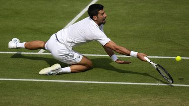 El serbio Novak Djokovic se cae al intentar un derechazo ante el español Carlos Alcaraz en la final masculina de Wimbledon el domingo 16 de julio del 2023. (AP Foto/Alastair Grant)