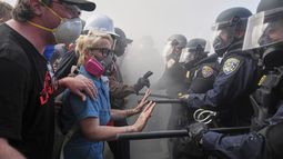 Manifestantes se enfrentan con la policía en la autopista 101, cerca del centro metropolitano de detención, el domingo 8 de junio de 2025, en Los Ángeles. (AP Foto/Jae C. Hong)