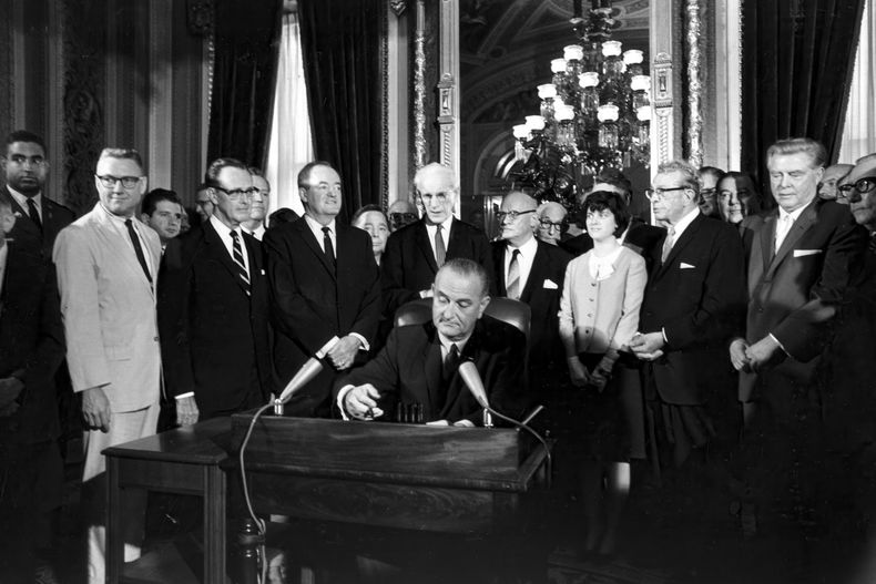 ARCHIVO – El presidente Lyndon B. Johnson firma la Ley de Derecho al Voto de 1965 en una ceremonia realizada en el Salón Presidencial cerca de las cámaras del Senado, en Washington, el 6 de agosto de 1965. Alrededor del presidente, de izquierda a derecha, directamente sobre su mano derecha, el vicepresidente Hubert Humphrey, el presidente de la Cámara de Representantes John McCormack, el representante Emanuel Celler, Luci Johnson, y el senador Everett Dirksen. Detrás de Humphrey está el líder de la mayoría de la Cámara, Carl Albert de Oklahoma, y detrás de Celler se encuentra el senador Carl Hayden. (AP Foto, Archivo).