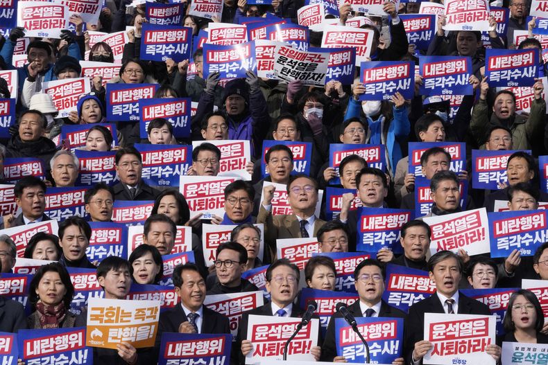 El líder del principal partido opositor de Corea del Sur, Lee Jae-myung, abajo en el centro, corea lemas durante una marcha contra el presidente, Yoon Suk Yeol en la Asamblea Nacional en Seúl, Corea del Sur, el miércoles 4 de diciembre de 2024. El cartel dice Yoon Suk Yeol debe renunciar. (AP Foto/Ahn Young-joon)