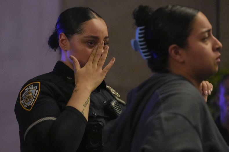 Una agente de la policía neoyorquina se enjuga las lágrimas afuera del Centro Médico Presbiteriano Weil Cornell de Nueva York, adonde fue trasladado un agente policial tras ser baleado en un edificio de oficinas de Manhattan, el lunes 28 de julio de 2025, en Nueva York. (AP Foto/Angelina Katsanis)