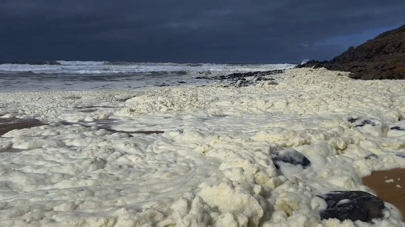 Esta imagen tomada de un video proporcionado por la Australian Broadcasting Corp. muestra espuma en la orilla de una playa el lunes 17 de marzo de 2025, en Waitpinga, cerca de Adelaida. (Australian Broadcasting Corp via AP)