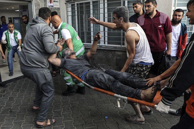 Un palestino herido es trasladado en una camilla al hospital de Al-Shifa, tras ataques aéreos israelíes sobre Ciudad de Gaza, en el centro de la Franja de Gaza, el lunes 16 de octubre de 2023. (AP Foto/Abed Khaled)