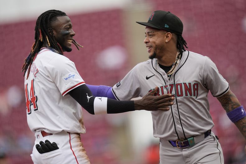 Elly De La Cruz (44) de los Rojos de Cincinnati y Ketel Marte de los Diamondbacks de Arizona se saluda, el jueves 9 de mayo de 2024, en Cincinnati. (AP Foto/Carolyn Kaster)